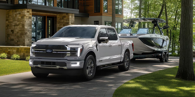 2026 Ford F-150 towing a boat, showcasing its power in a comparison with the Silverado 1500 in Sunrise, FL.