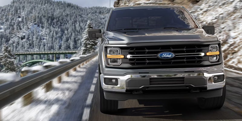 2026 Ford F-150 driving beside a guardrail on a snow-covered road, featured by Sawgrass Ford in Sunrise, FL